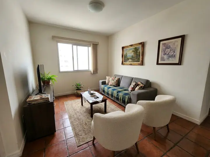 Sala antes, com piso de cerâmica vermelha e quadros antigos